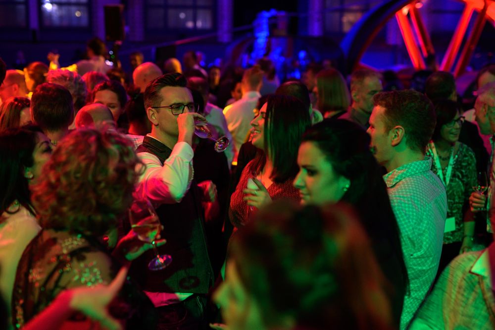 People dancing in brightly coloured lights during the EPIC2019 convention in Berlin